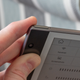 A finger next to the InkNote Color's lock button.